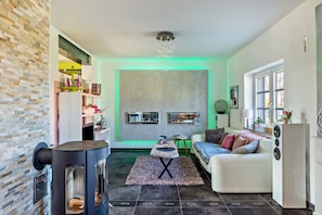 Una sala de estar con chimenea, un sofá, una mesa de centro y un televisor.