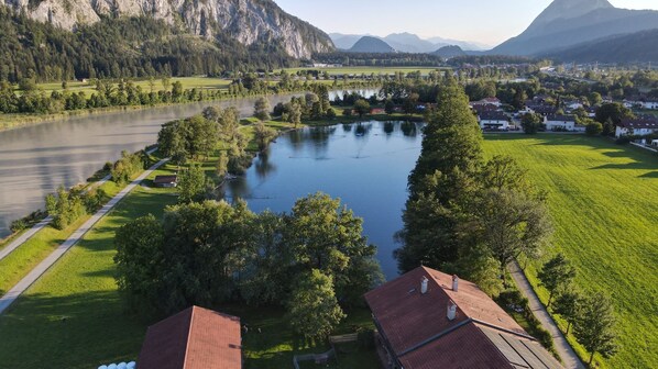 Blick auf einen Fluss mit einem Haus und einem kleinen Anlegesteg.