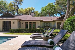 A house with a swimming pool, outdoor lounge chairs, and a well-maintained garden. - Beautiful Family Home Located Near Sea Island (Saint Simons Island)