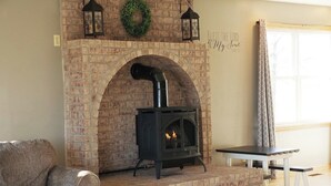 A living room with a brick fireplace, a sofa, and a table.