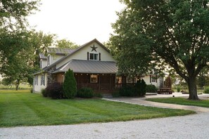 A house with a star on the roof, a front porch, and a gravel driveway. - Family Farm Stay Near Route 66 | Animals & Fire Pit (LaRussel)