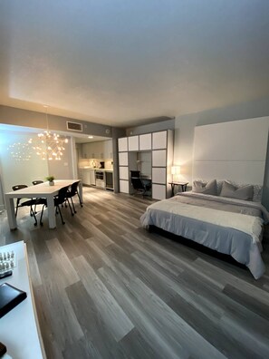 Cozy retreat with a large bed, dining area, and kitchenette.