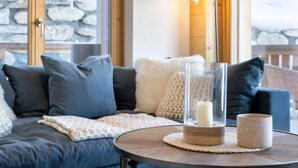 A cozy living room with a sofa, cushions, a glass candle holder, and a lamp. - Les Terrasses de Nendaz D1 by Interhome (Nendaz)