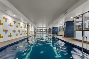 Relax by the rectangular pool surrounded by colorful tiles and natural light.