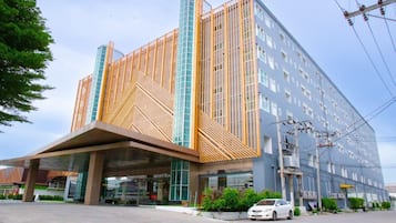 A modern hotel with a distinctive facade featuring a geometric pattern and a large entrance.