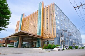 A modern hotel with a distinctive facade featuring a geometric pattern and a large entrance. - Le Srivaree Suvaranabhumi Airport Hotel (Bang Phli)