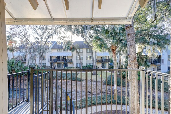 Enjoy a tranquil outdoor space with a pergola, surrounded by lush greenery and pedestrian access.