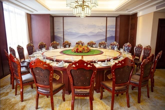 A conference room with a round table, chairs, and a chandelier.