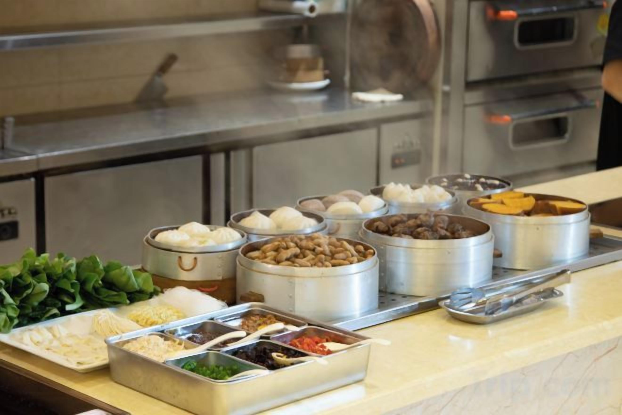 A buffet with various food items in metal containers.