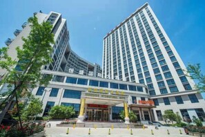 Un hôtel moderne doté d’une entrée imposante, de plusieurs étages et offrant une vue dégagée sur le ciel.