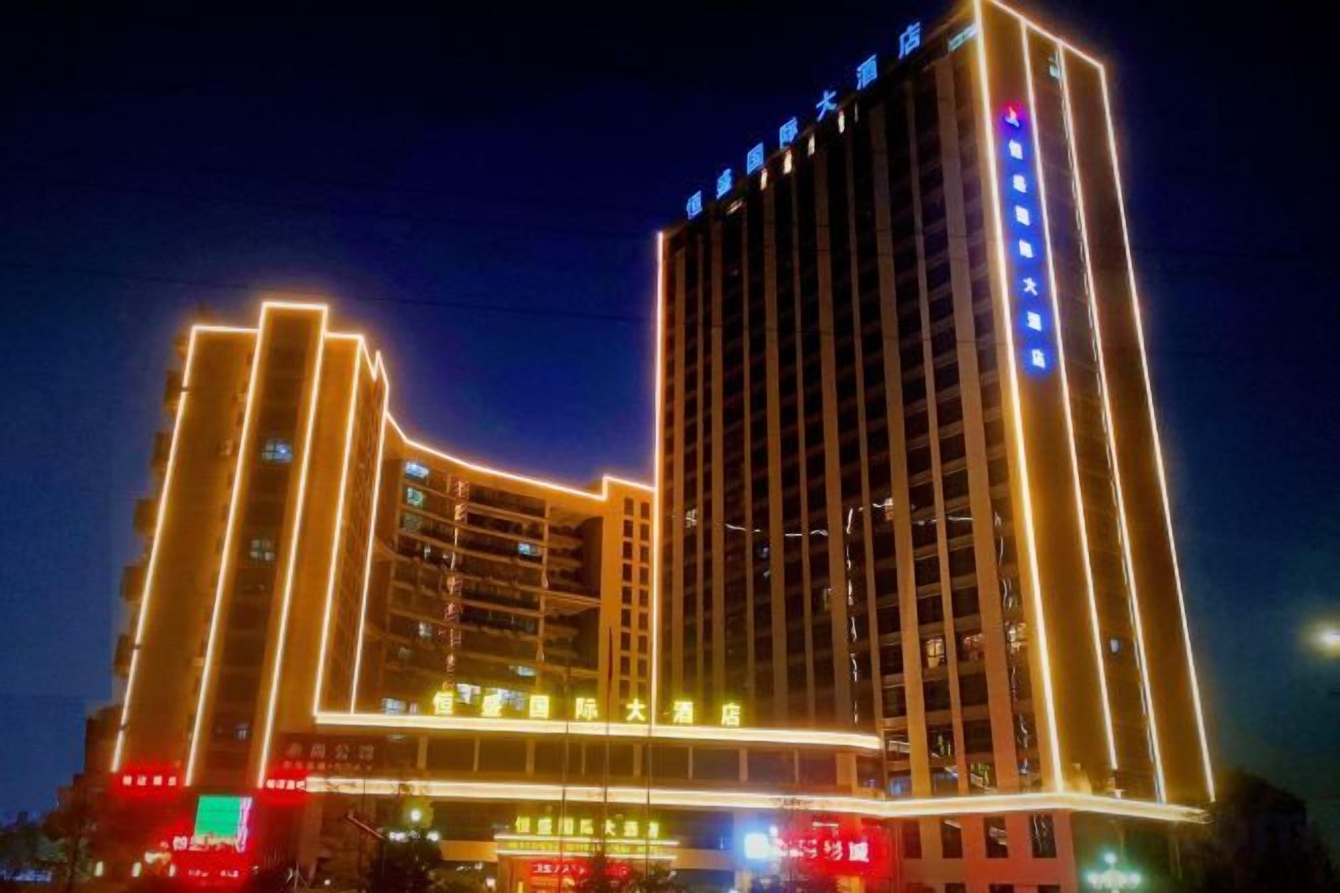 A multi-story hotel with illuminated vertical lines and signage.