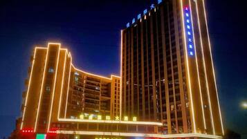 A multi-story hotel with illuminated vertical lines and signage.