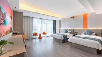 Una habitación de hotel moderna con dos camas, un escritorio y una zona de comedor.