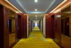 Ein Hotelgang mit Holztüren, Teppichboden und einer langen Korridor.