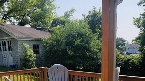 Eine Holzterrasse mit Tisch und Stühlen, umgeben von einem Hollerleger.