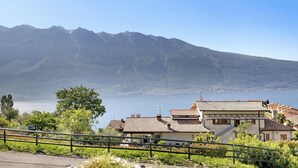 A coastal village with traditional architecture, a mountain backdrop, and a view of the sea. - Apartment "Casa Lucy" with Lake View, Shared Pool & Wi-Fi (Tremosine sul Garda)