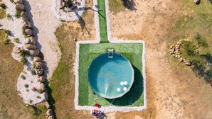 An aerial view of a swimming pool surrounded by a pebble path, with a small dock and a boat. - Holiday Home 'Villa S'ena E Su Juncu' with Mountain View, Wi-Fi & Air Conditioning (loculi)