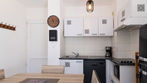 A modern kitchen with white cabinets, a sink, a coffee maker, and a microwave. - Holiday Apartment "Poggio Mezzana" with Sea View, Shared Pool & A/C (Santa-Lucia-di-Moriani)