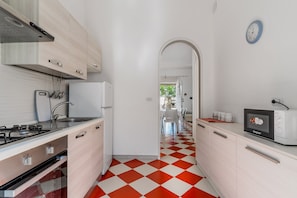 A modern kitchen with a checkered floor, a microwave, and a sink.