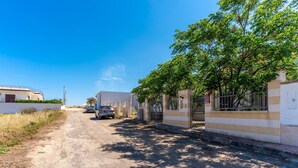 Eine Wohnstraße mit Häusern, parkenden Autos und blauem Himmel.