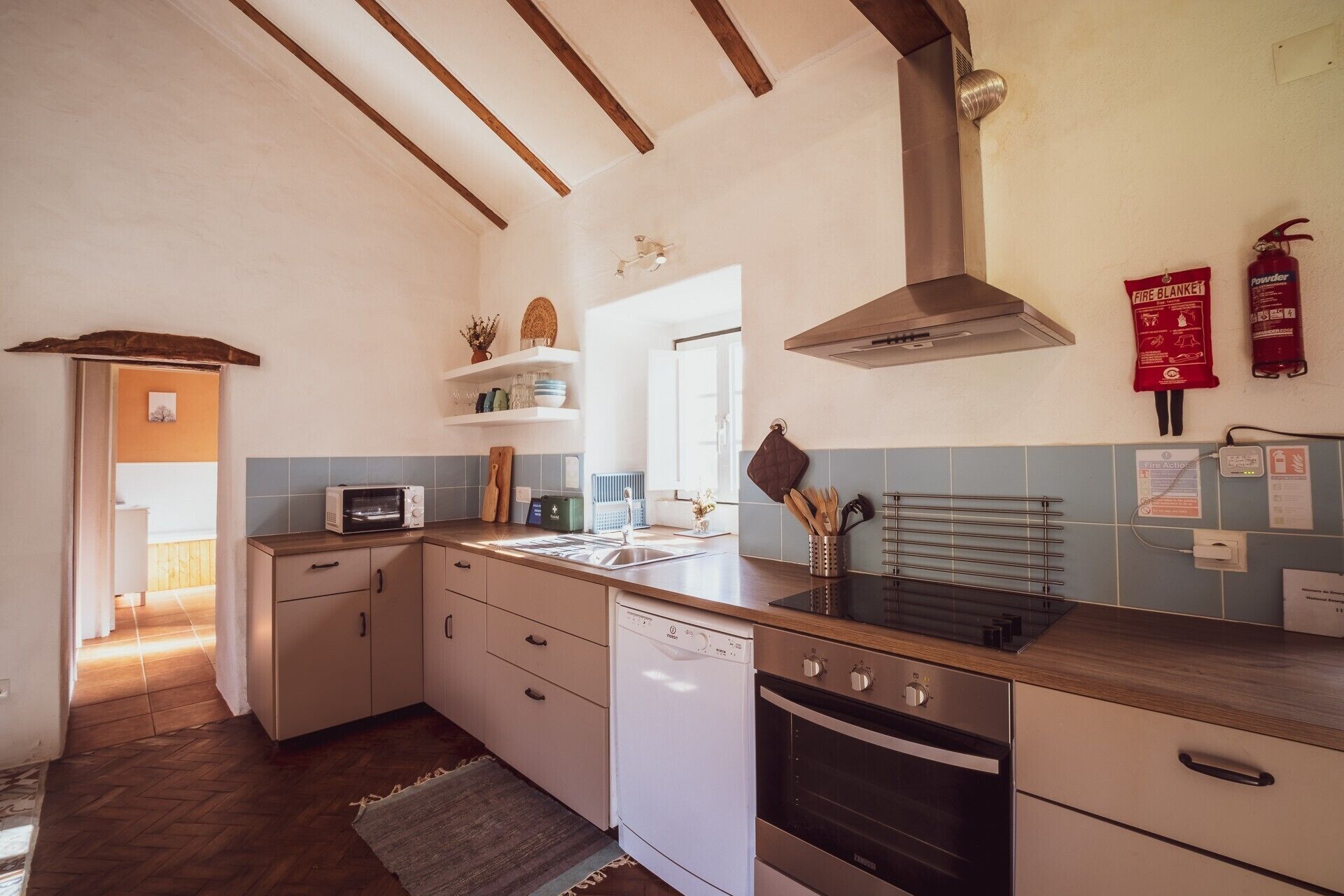 Uma cozinha compacta com lava-louças, forno e micro-ondas.