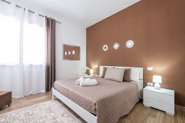 Une chambre à coucher comprenant un lit, une table de chevet et un luminaire fixé au mur.