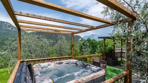 A hot tub with a wooden pergola structure, surrounded by lush greenery and a mountainous backdrop. - Apartment 'Georesort D2' with Mountain View, Wi-Fi and Air Conditioning (Tremosine)
