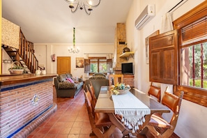 A dining area with a brick wall, wooden table, and chairs.