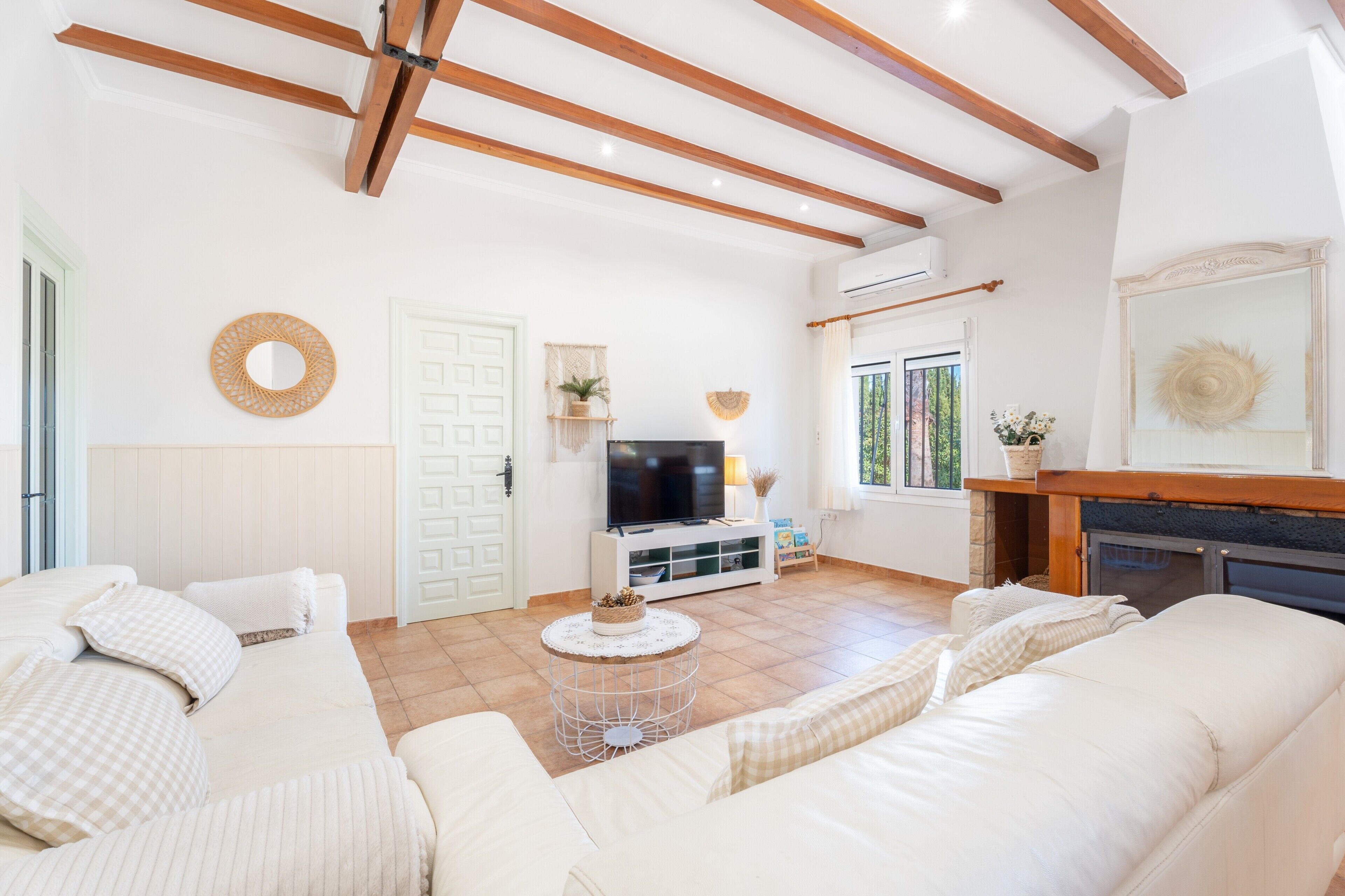 Una sala de estar con sofá, televisión, chimenea y elementos decorativos.