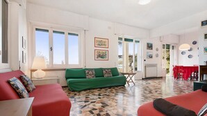 A room with a green sofa, red armchairs, a patterned floor, and artwork on the walls. - Villa 'Uliveto' with Sea View, Wi-Fi and Air Conditioning (Camogli)