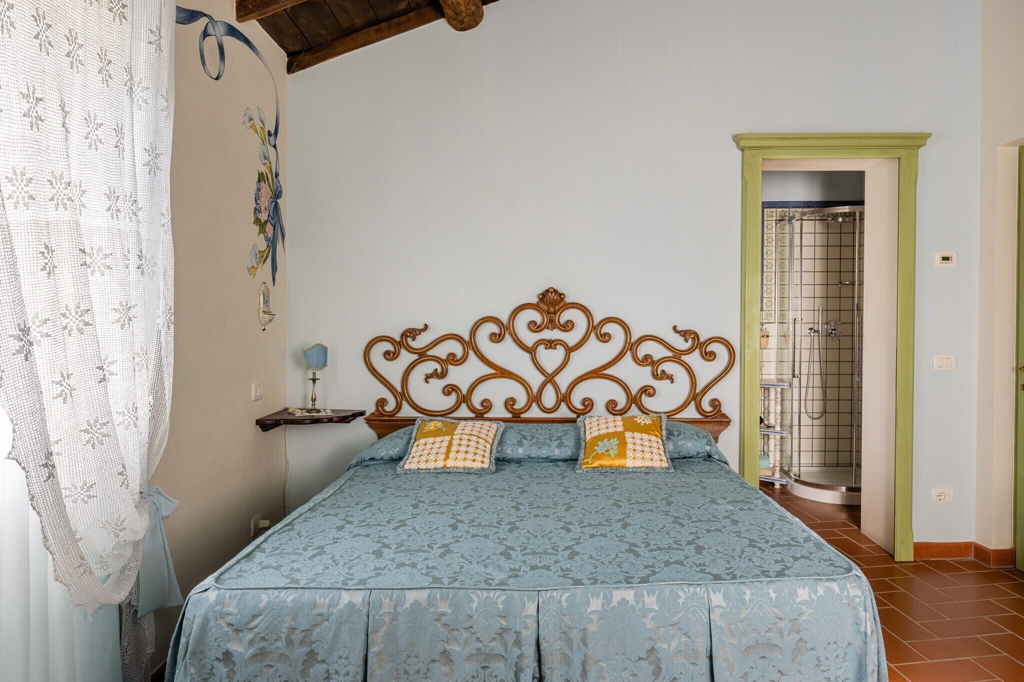 Une chambre à coucher avec un lit, une table de chevet, un mur décoratif et une porte de salle de bain.
