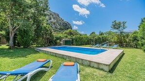 A swimming pool with lounge chairs and a mountain backdrop. - Holiday Home 'Sontuiri Den Jaume' with Private Pool, Wi-Fi and Air Conditioning (Pollença)