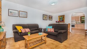 A living room with two sofas, a wooden coffee table, and a kitchen in the background. - Holiday Home 'Sontuiri Den Jaume' with Private Pool, Wi-Fi and Air Conditioning (Pollença)