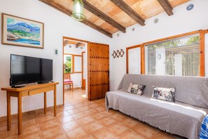 Un salon avec un téléviseur, un canapé et une porte en bois.