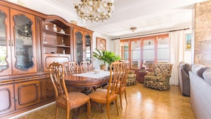 A dining area with a wooden table and chairs, a large wooden cabinet, and a potted plant. - Country House 'Na Penyal Ref 246' with Sea View, Private Pool and Wi-Fi (Cala Millor)