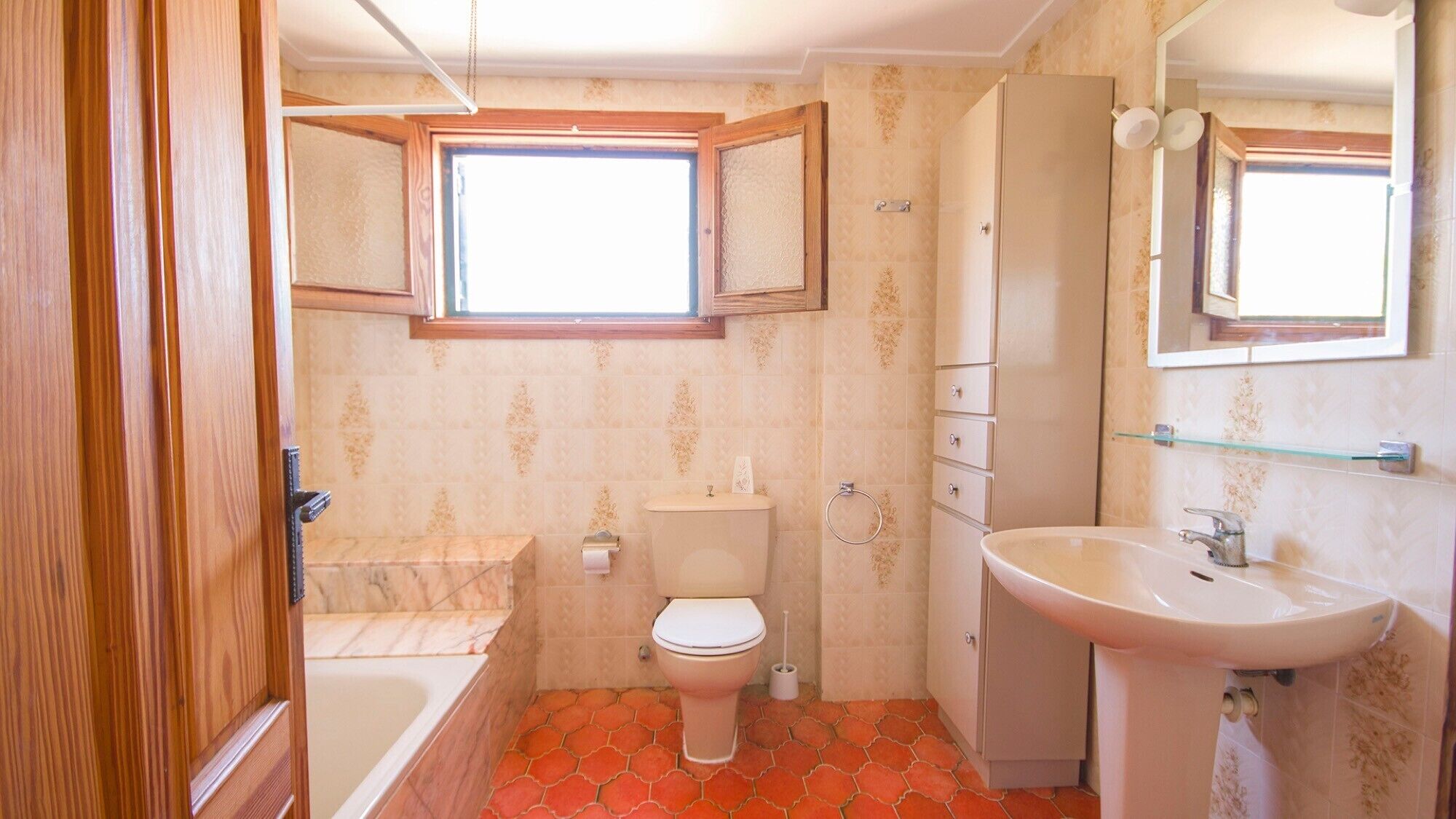 Ein Badezimmer mit Toilette, Waschbecken und Badewanne.