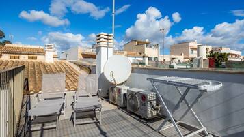 A rooftop terrace with air conditioning units, a satellite dish, and a drying rack.