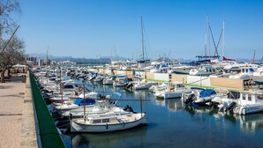 A marina with numerous boats docked, a clear sky, and a distant mountain range. - Minimal Apartment Ref 9000 with Sea View, Balcony, Wi-Fi and Air Conditioning (Can Picafort)
