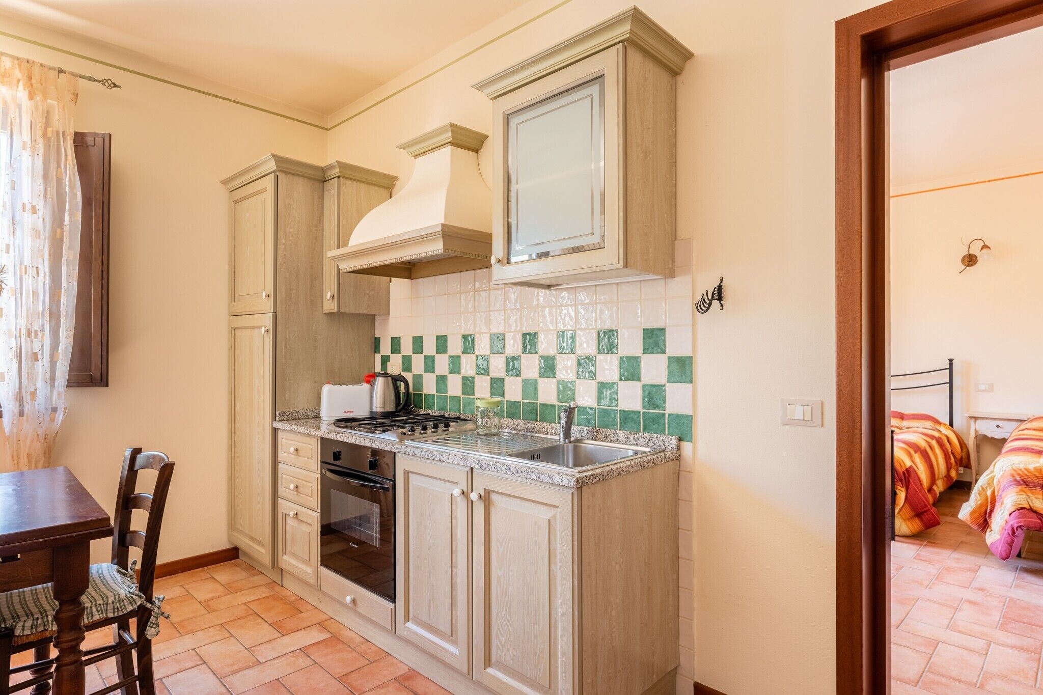 A compact kitchen with a stove, oven, and a dining area with a table and chairs.