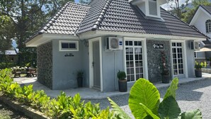 Een gebouw met een grijze pannendak, een stenen muur en een bord met de tekst '9 Poppy Villa'.