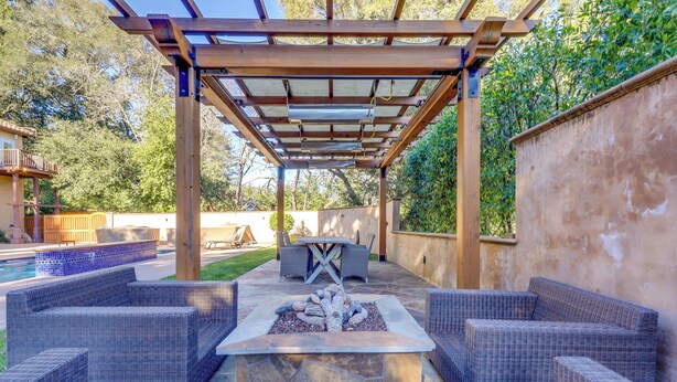 An outdoor patio with a fire pit, wicker furniture, and a pergola structure. - Santa Rosa Home w/ Private Pool & Tennis Court (Santa Rosa)