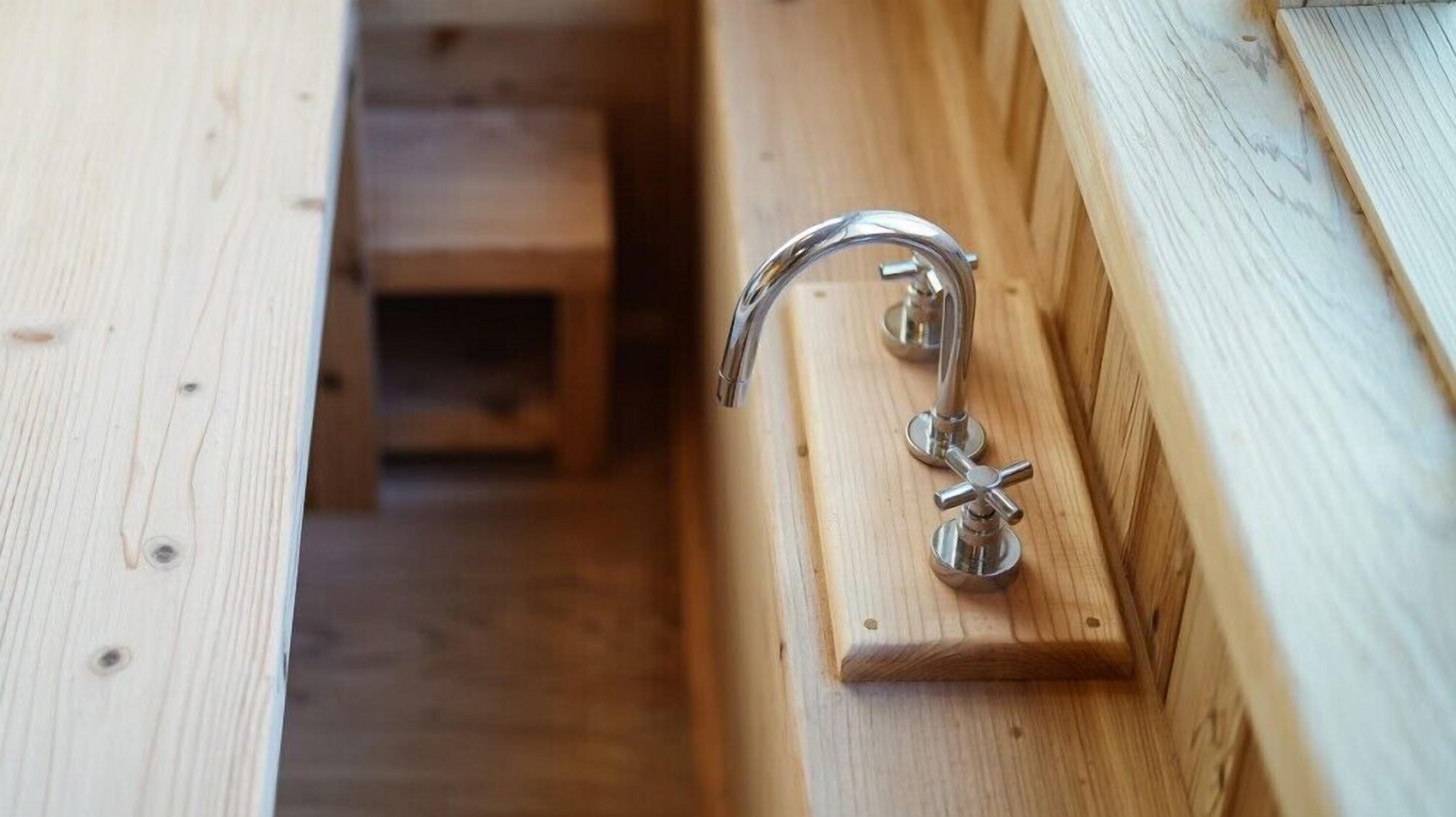 A wooden door with a silver handle and a small, square, wooden panel.