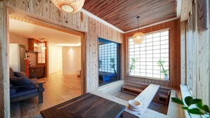Ein Holzinterieur mit einer Couch, einem Esstisch und einem großen Fenster mit Aussicht.