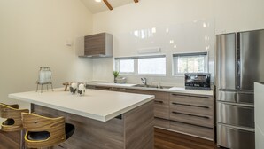 A modern kitchen with a central island, stainless steel appliances, and wooden accents.