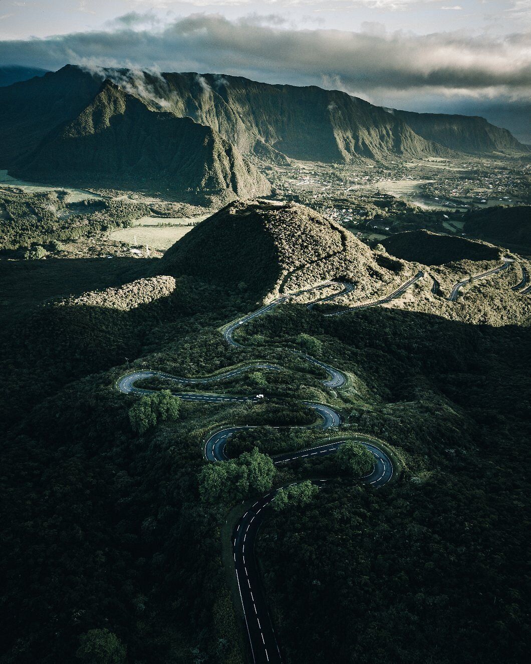 A winding road through a mountainous landscape with a valley below.
