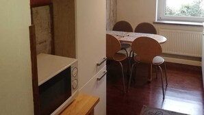 Une cuisine de taille réduite comprenant un coin repas, une fenêtre avec vue et un radiateur.