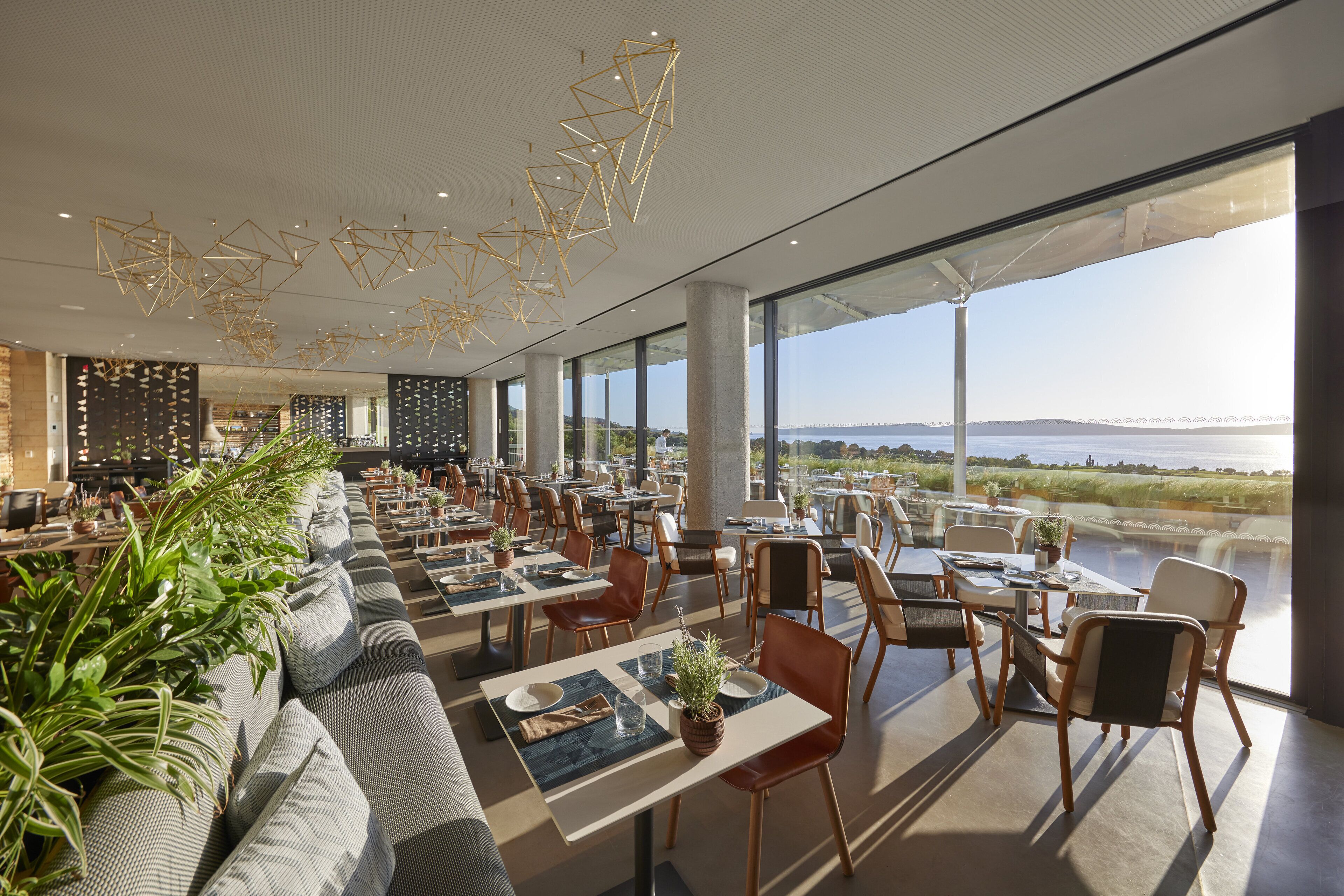Ein modernes Restaurant mit einer langen Essbereich, großen Fenstern und Blick auf das Wasser.