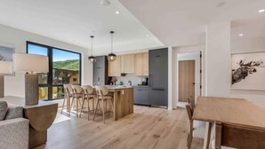 A modern kitchen with wooden cabinets, a central island, and pendant lighting. - Electric Pass Lodge 509 (Snowmass Village)