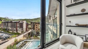 A modern interior with a large window overlooking a residential area and a swimming pool. - Electric Pass Lodge 607 (Snowmass Village)