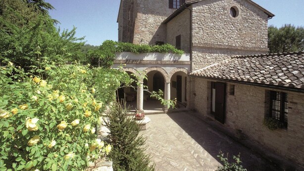 Ein Gebäude aus Stein mit Innenhof, Bogenarkaden und einem Ziegeldach.